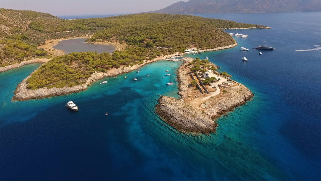 Agistri island from the air, pine forest down to the turquoise coves of the west coast, Saronic Gulf
