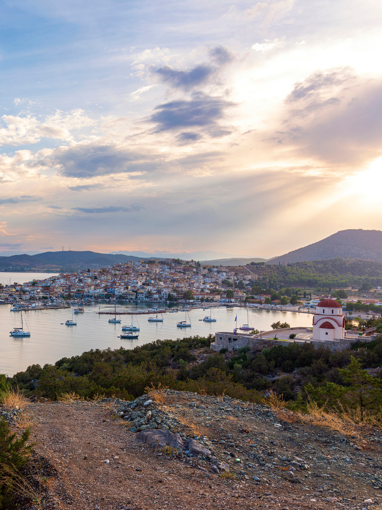 Beautiful view of Ermioni sea lagoon with moored yachts and boats at sunset time.