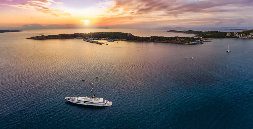 Aerial sunset view over the bay of Vouliagmeni on the Athens Riviera with a yacht at anchor