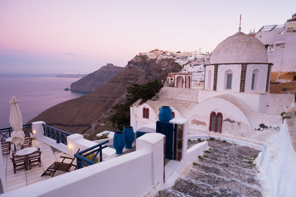 Fira on Santorini at sunset, a domed church on the caldera rim