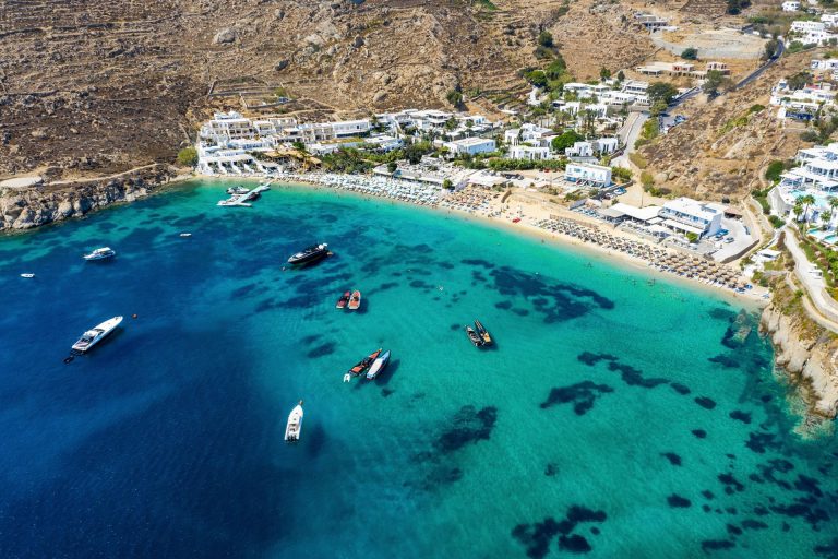 Aerial view of Psarou bay on Mykonos with yachts at anchor off the Nammos beach
