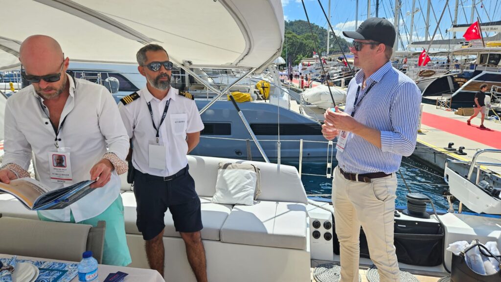 DMA Yachting brokers talking with a yacht captain on the aft deck at a Greek yacht show