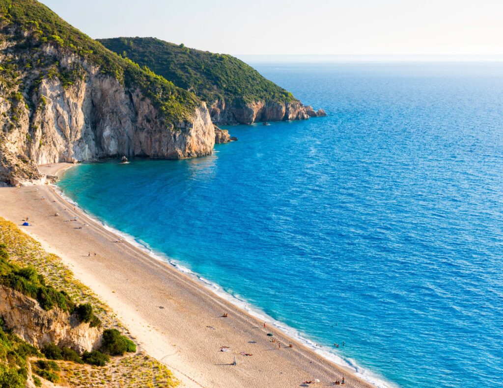 Beautiful sandy beach on Milos Island in the Cyclades Islands in Greece with steep cliffs and blue sea