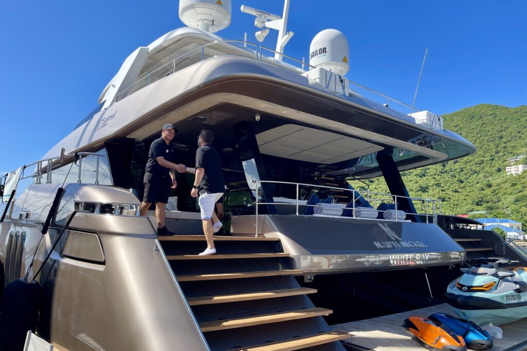 Charter broker Alex Hailwax meeting the crew on the aft deck of a motor yacht