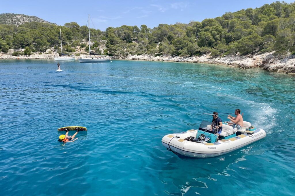Wakeboarding off the tender of motor yacht ANKA in a sheltered pine-fringed cove in Greece