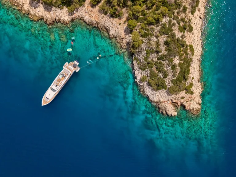 Motor Yacht DRAGON tied stern to the rocks