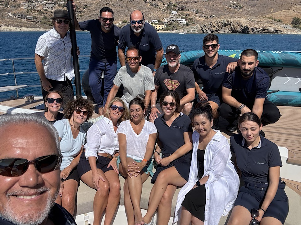 Guest group relaxing on the foredeck of a charter catamaran in Greece