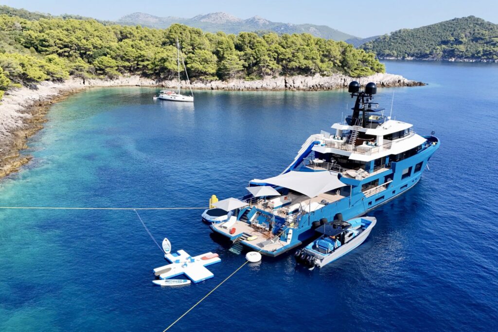 Superyacht KING BENJI anchored with stern lines to the shore in a protected Greek bay, tender and toys alongside