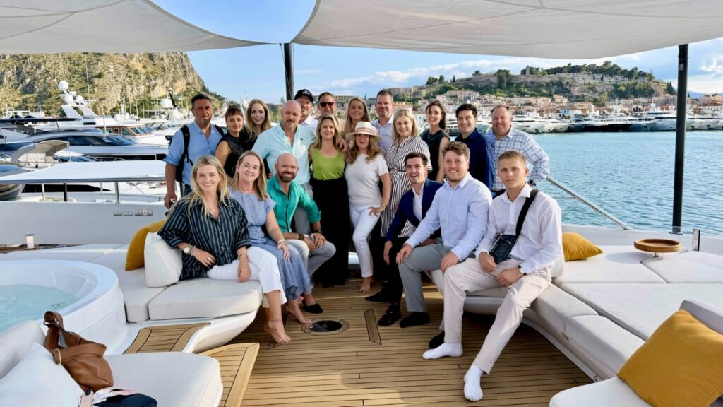 The DMA Yachting team gathered on the sundeck of a yacht at a show in Nafplio