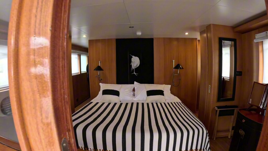 A double cabin with a striped bedcover on motor yacht SOUNION II