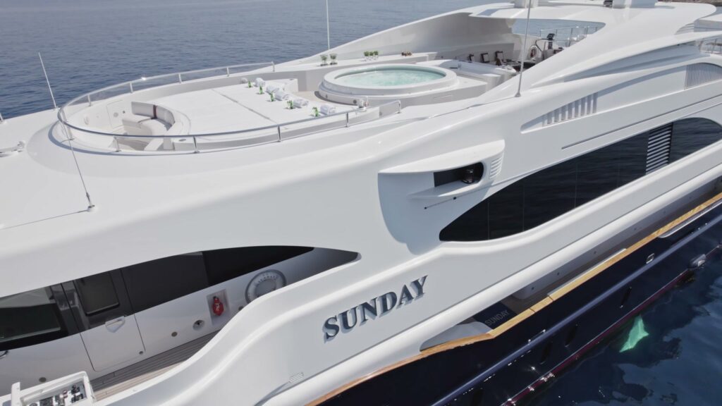 The name SUNDAY on the hull of the 60 m Benetti, with the sun deck jacuzzi above