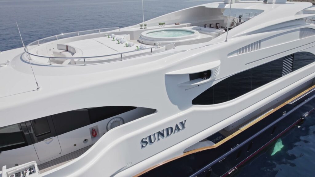 The name SUNDAY on the hull of the 60 metre Benetti, with the sun deck jacuzzi above