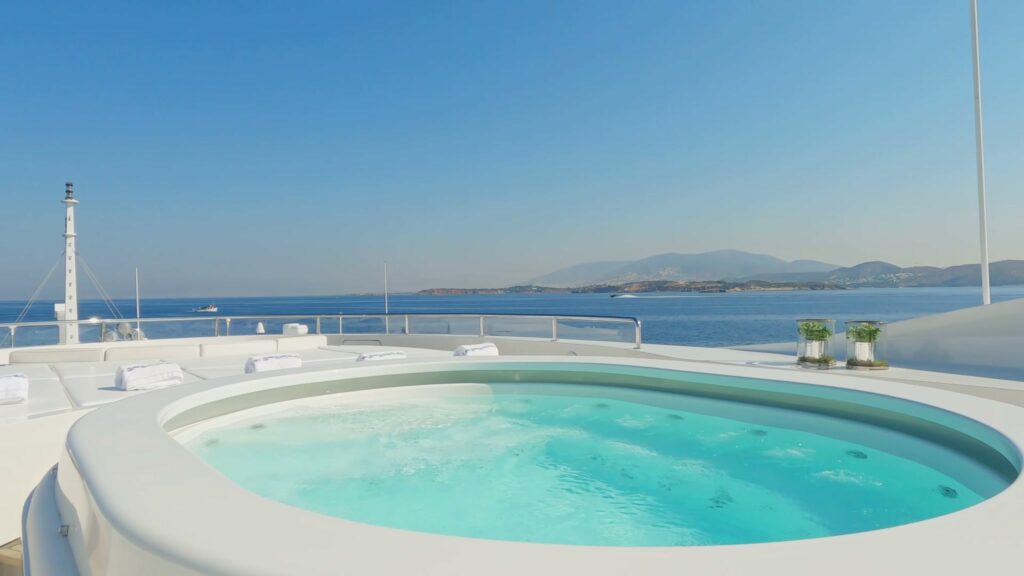 Sun deck jacuzzi on Benetti motor yacht SUNDAY, looking out over a Greek bay