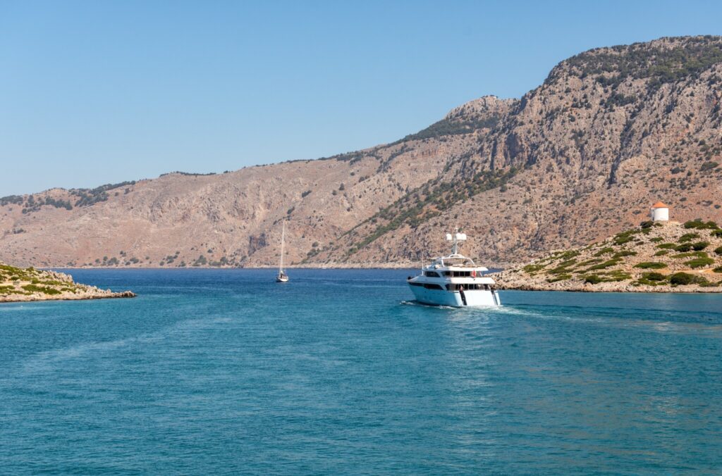 Motor yacht leaving the blue lagoon at Symi in the Dodecanese on a Greece yacht charter
