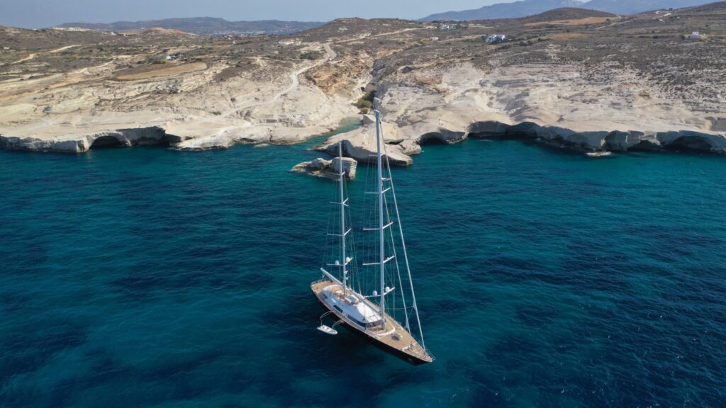 Sailing superyacht anchored off the white chalk cliffs of Sarakiniko on Milos in the Cyclades