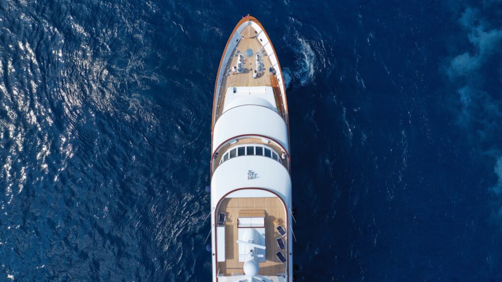 Aerial view of a superyacht anchored in deep blue water off Super Paradise beach, Mykonos