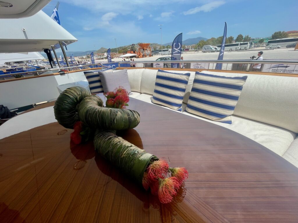 Flower arrangement on ARTEMISEA's flybridge table, striped cushions behind