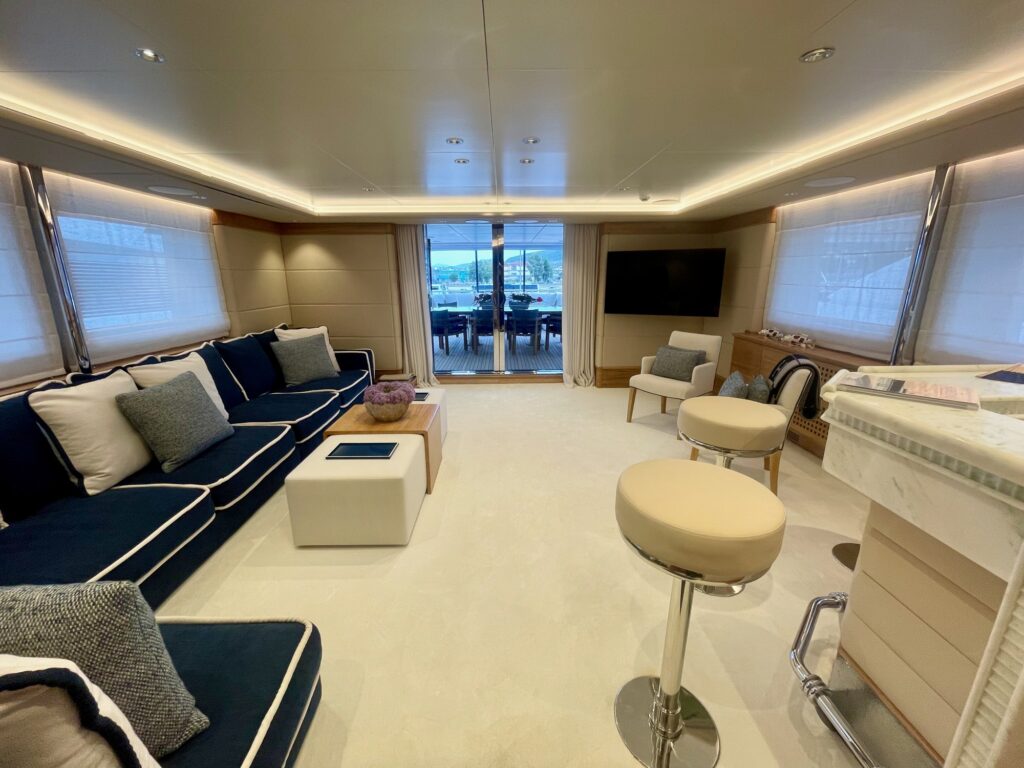ARTEMISEA's sky lounge with a navy sofa, bar stools and a wall TV