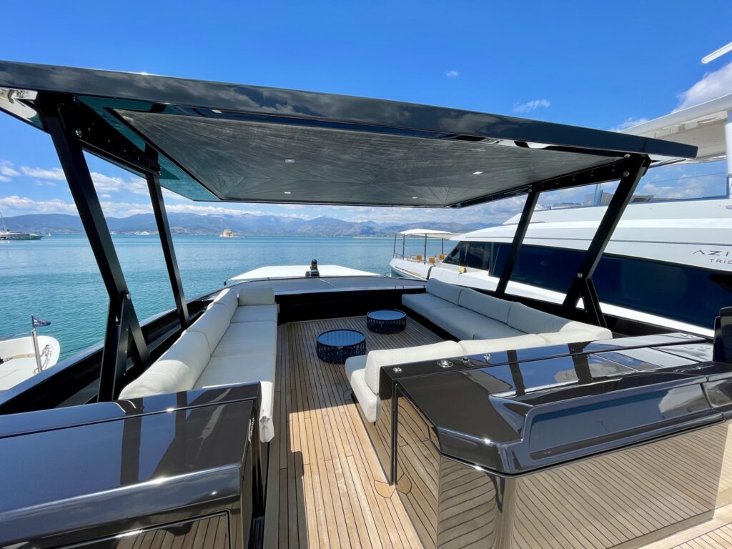 The shaded sundeck lounge on motor yacht BESTIA, with sofas under the hardtop, May 2026.
