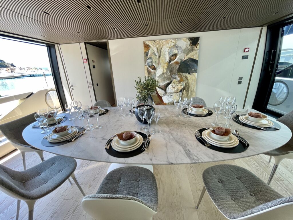 A round marble dining table set for eight in the upper saloon of motor yacht BESTIA, May 2026.