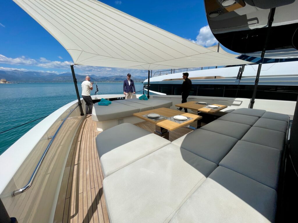 BESTIA's foredeck sunpads under the sail awning, Nafplio bay behind