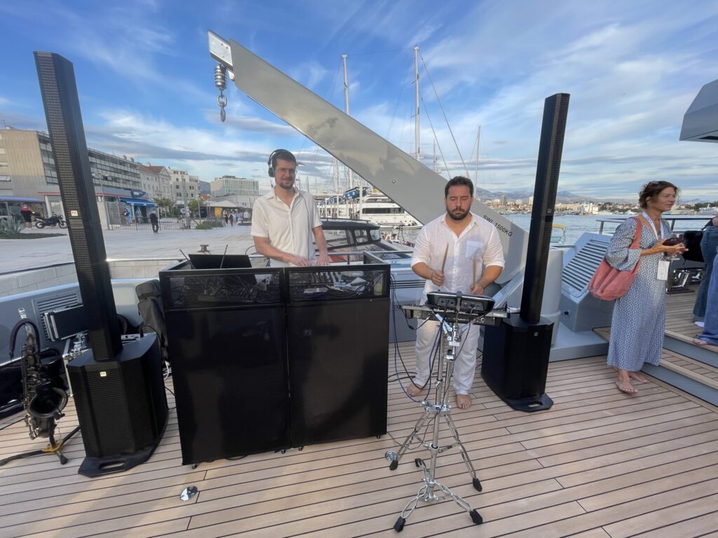 A DJ and live musician on deck during a party on motor yacht CARMEN, October 2025.