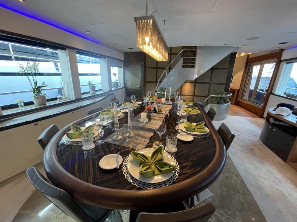 The dining table set for dinner in the saloon of motor yacht CARMEN, October 2025.