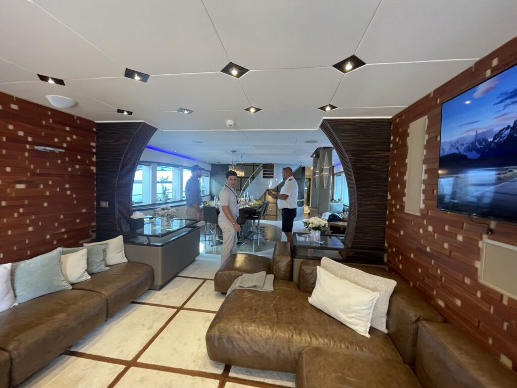 The main saloon of motor yacht CARMEN with brown leather sofas, October 2025.