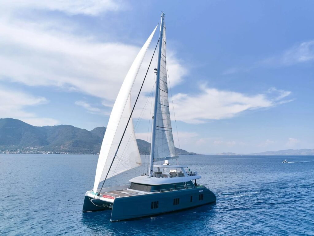 GENNY, a dark grey Sunreef 80 charter catamaran, under sail in Greece