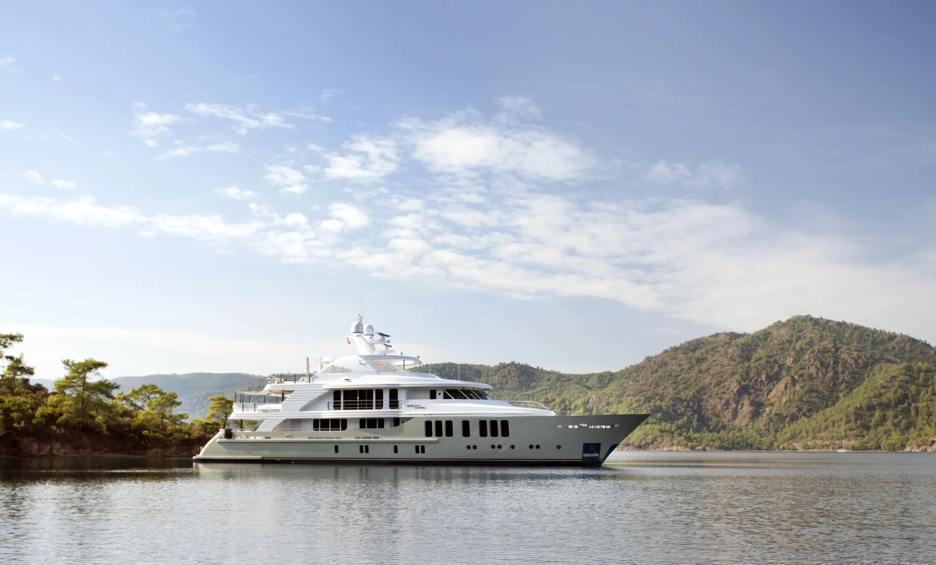 ORIENT STAR superyacht at anchor in a pine-lined bay, 154 ft CMB Yachts