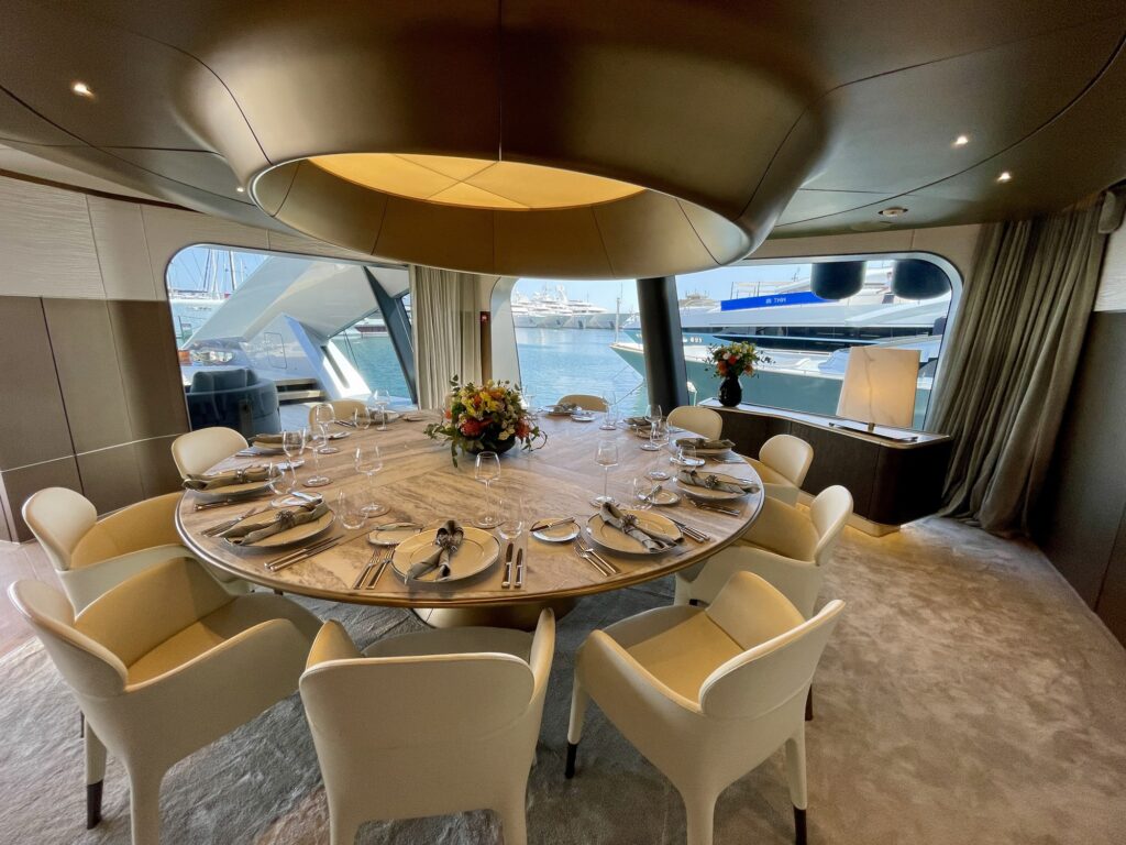 Round dining table set for eight beneath a circular ceiling feature on THIS IS IT