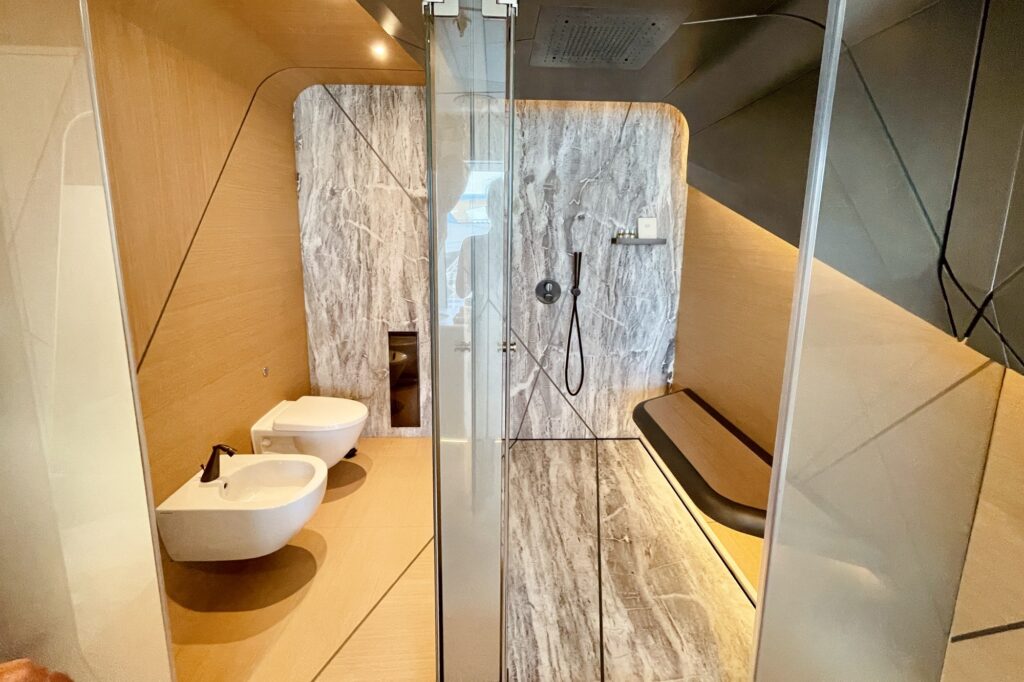 Master bathroom on THIS IS IT with marble shower wall and glass enclosure