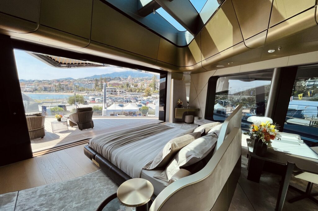Master bed under a skylight on THIS IS IT, glass wall folded open to a private balcony