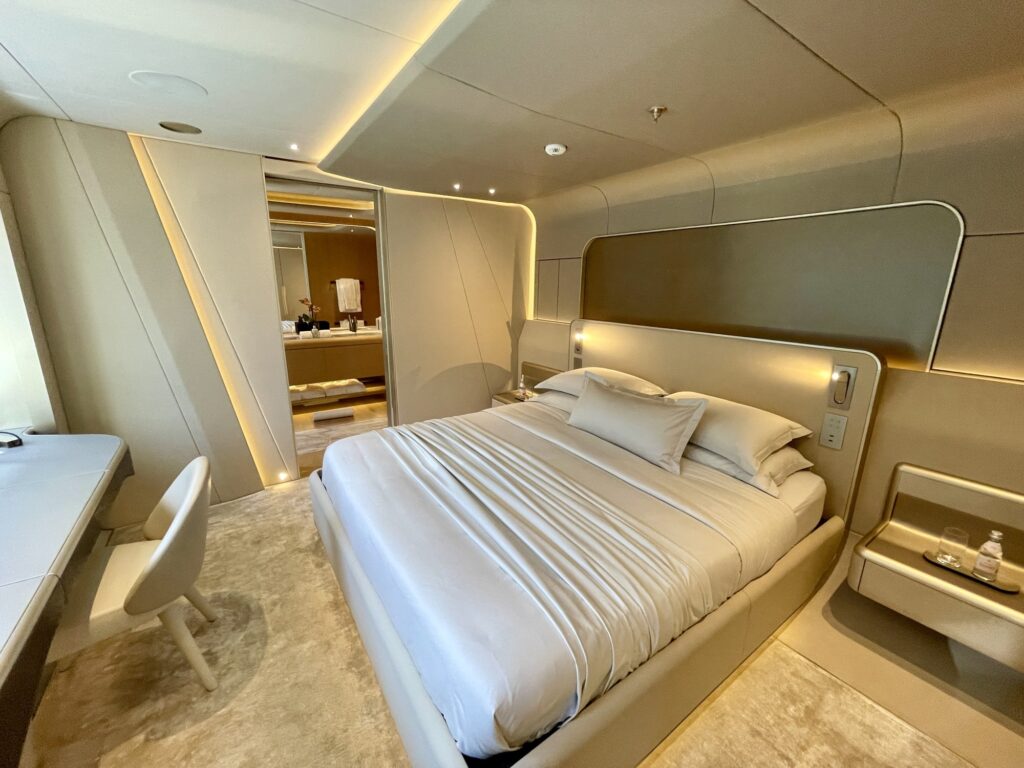 White-dressed bed and side desk in a VIP cabin on THIS IS IT