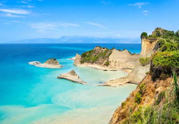 Cape Drastis cliffs near Sidari and Peroulades on Corfu island in Greece. Famous rock formations with small beach and rugged coastline. Popular Greek destination for summer vacation