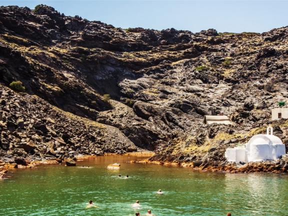There is a number of hot springs sprinkled around the volcanic Nea Kameni. Your captain will know the less visited ones.