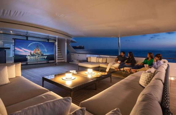 Family watching disney movie on the flybridge cinema of a luxury Motor yacht