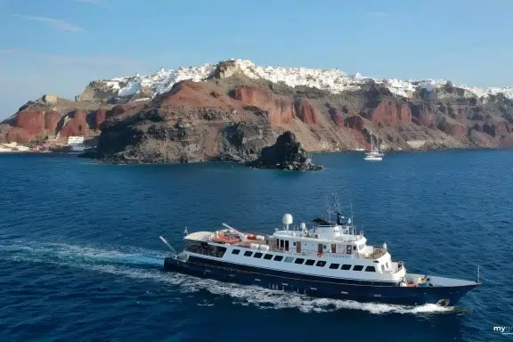 Motor Yacht Callisto cruising past Santorini. CALLISTO is licensed to carry up to 34 guests on charters in Greece