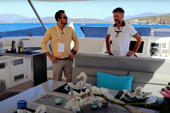 Tour of the Flybridge Onboard Power Catamaran Skylark: Charter Broker Alex Hailwax (on the left) talks to Captain Jez Flecher of Skylark at the EMMYS 2024 in Poros