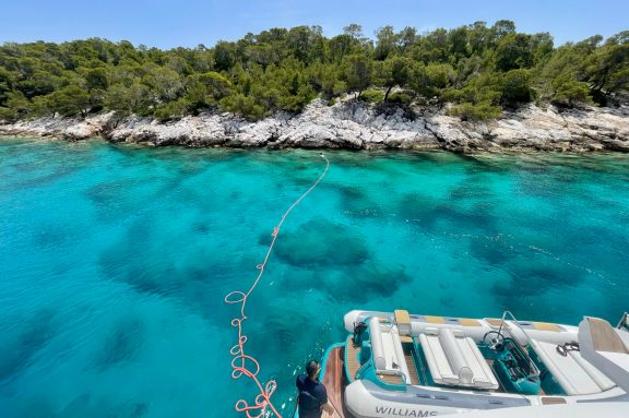 Deckhand swims ashore with the stern line to tie off to the rocks at Agistri Island, motor yacht ANKA