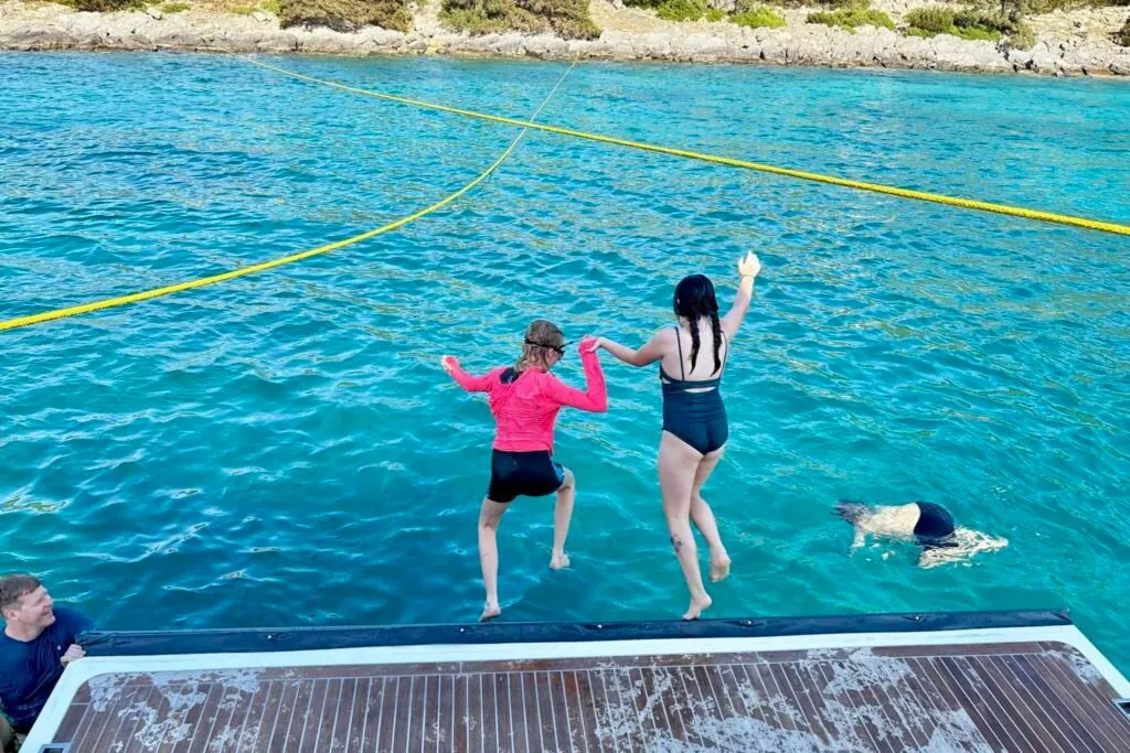 Kids jumping off swim platform
