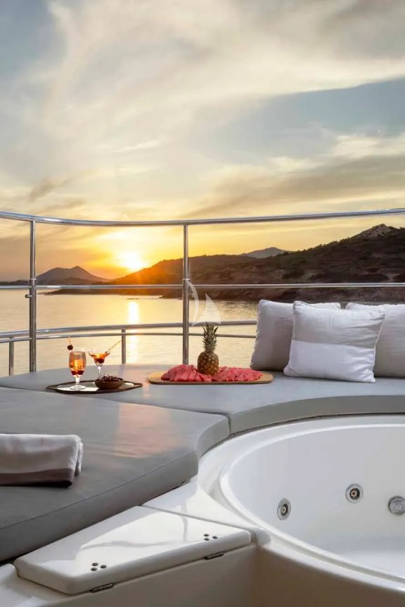 The spacious unobstructed sundeck has a jacuzzi pool with a large sunbathing area all around it, a bar, a dining table and sunbeds