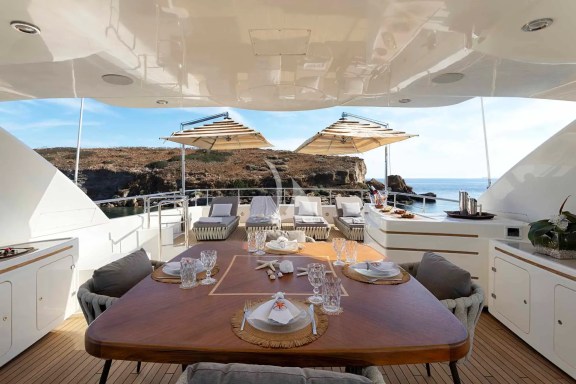 The spacious unobstructed sundeck has a jacuzzi pool with a large sunbathing area all around it, a bar, a dining table and sunbeds