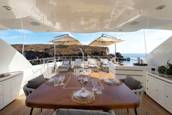 The spacious unobstructed sundeck has a jacuzzi pool with a large sunbathing area all around it, a bar, a dining table and sunbeds
