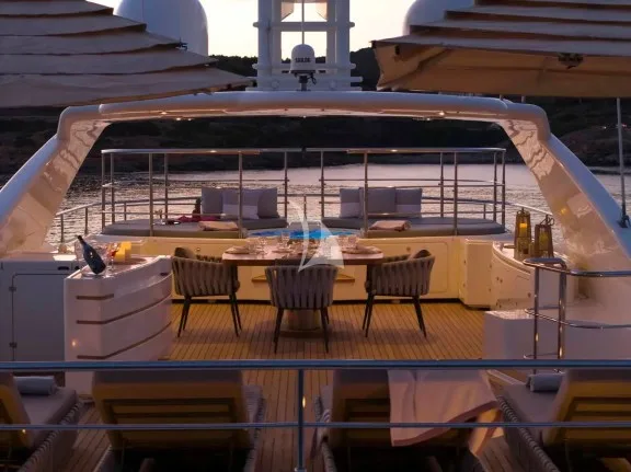 The spacious unobstructed sundeck has a jacuzzi pool with a large sunbathing area all around it, a bar, a dining table and sunbeds