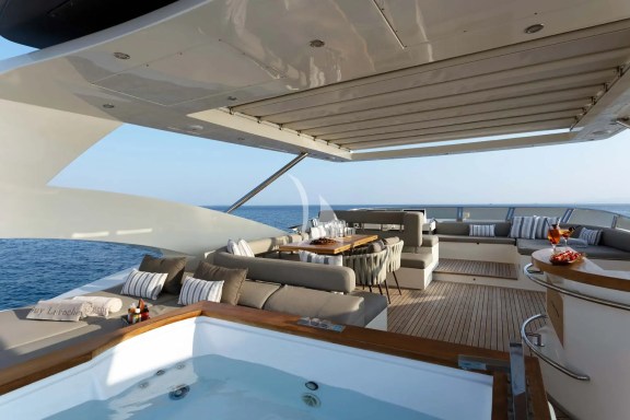 The exceptionally spacious Fly Bridge has a large Jacuzzi, hard top with electrically retractable canvas roof, a bar, a large foldable dining table, lounges & sunbathing areas