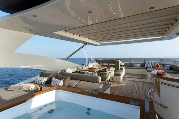 The exceptionally spacious Fly Bridge has a large Jacuzzi, hard top with electrically retractable canvas roof, a bar, a large foldable dining table, lounges & sunbathing areas