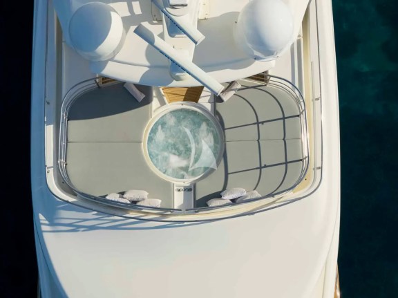 The spacious unobstructed sundeck has a jacuzzi pool with a large sunbathing area all around it, a bar, a dining table and sunbeds