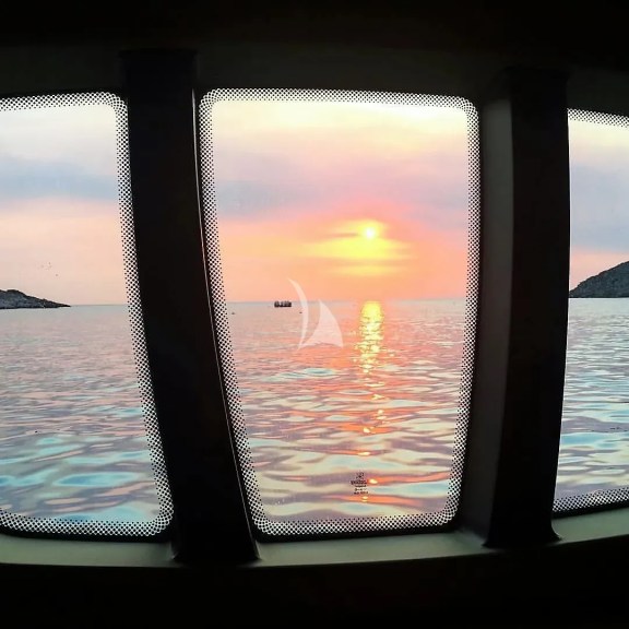 Master Cabin, window. Sunset in Fleves islet, Athens Riviera