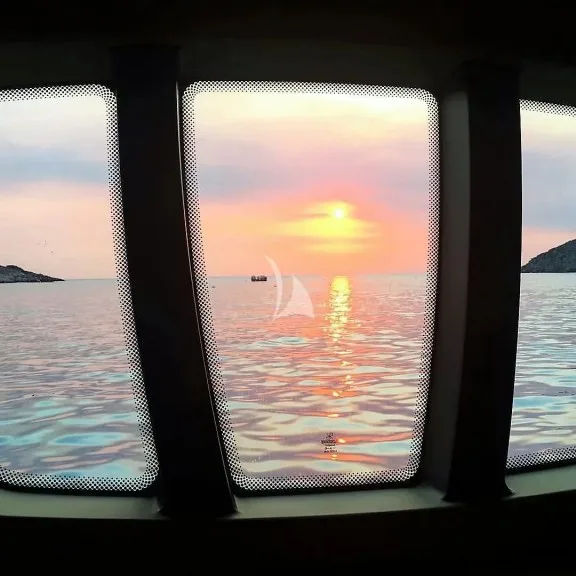Master Cabin, window. Sunset in Fleves islet, Athens Riviera
